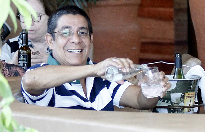 Zeca Pagodinho mostra para fotógrafo que está bebendo água em restaurante