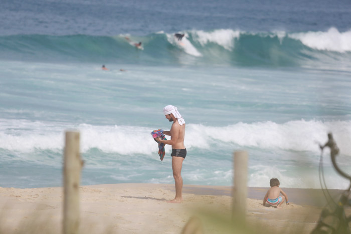 Daniel de Oliveira se diverte com os filhos enquanto malha na praia da Reserva, no Rio 