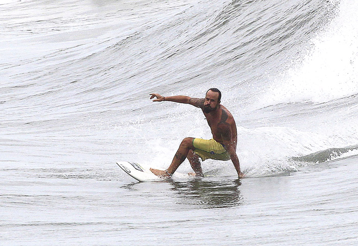 De verde e amarelo, Paulinho Vilhena surfa na Prainha