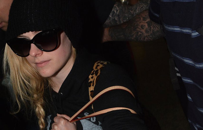 Avril Lavigne aterrissa em solo verde e amarelo