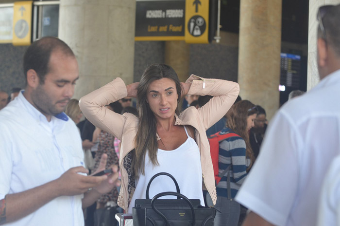 Nicole Bahls manda beijinho ao desembarcar no Rio de Janeiro