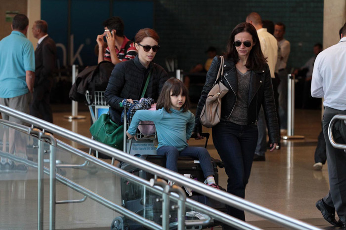 Débora Falabella circula em aeroporto com a filha em cima das malas