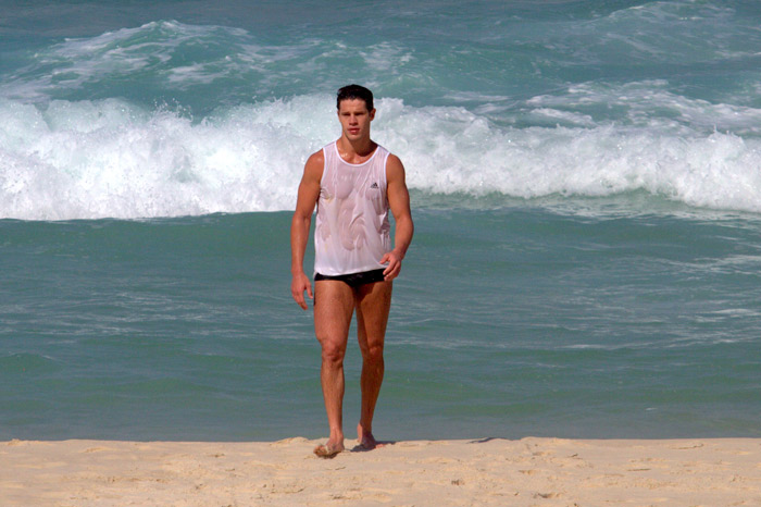 José Loreto fica com a camiseta molhada ao entrar no mar vestido