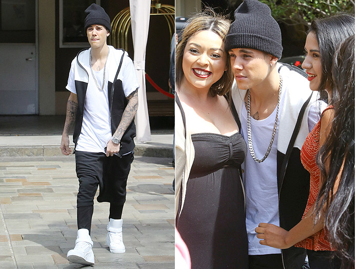 Justin Bieber posa para foto com fãs em saída de hotel