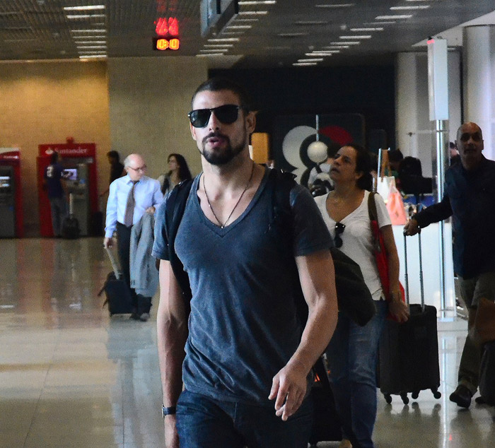 Cauã Reymond acena para os fotógrafos em aeroporto no Rio