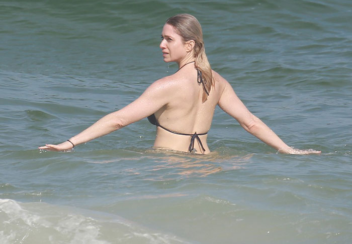 Letícia Spiller mostra todas as suas curvas ao se refrescar na praia