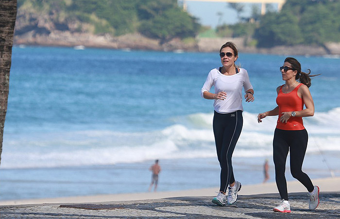 Adriana Esteves acena para fotógrafo enquanto corre na orla carioca