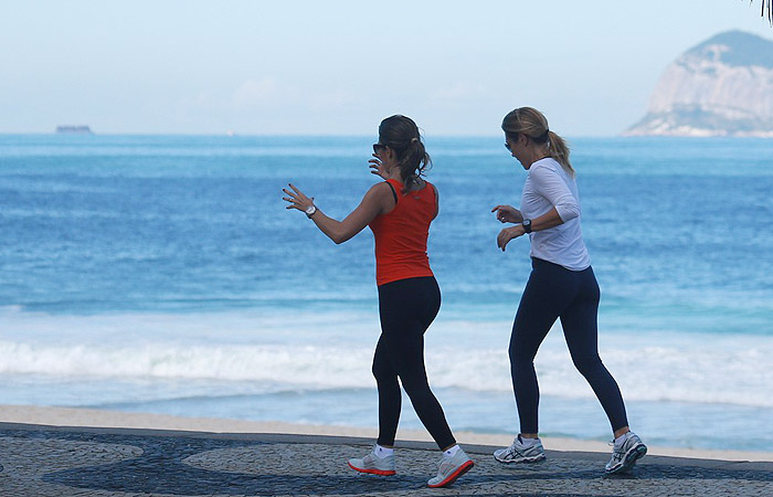 Adriana Esteves acena para fotógrafo enquanto corre na orla carioca