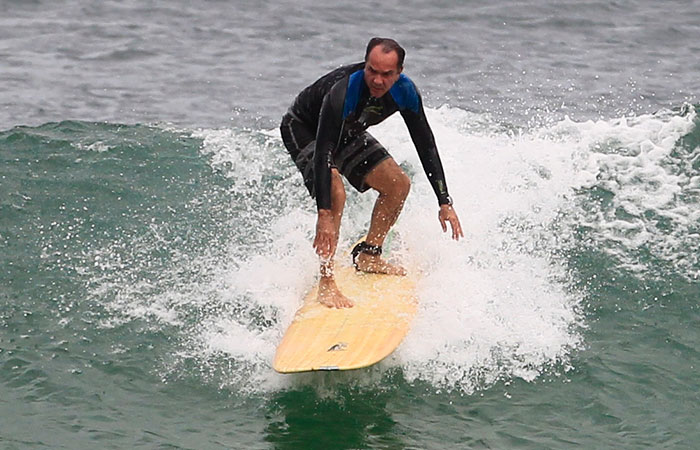 Humberto Martins troca de roupa na praia antes de surfar