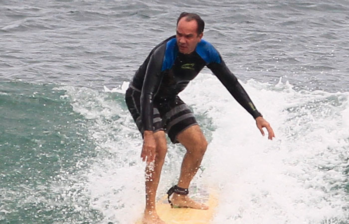 Humberto Martins troca de roupa na praia antes de surfar