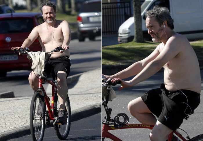 Sem camisa, Leonardo Medeiros pedala pela orla da Barra da Tijuca, no Rio