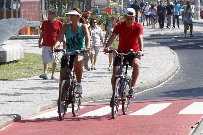 Bebeto pedala na orla da Barra da Tijuca com a mulher