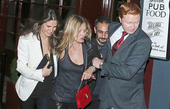 Ops, bebi demais... Top Kate Moss sai de restaurante amparada por amigos