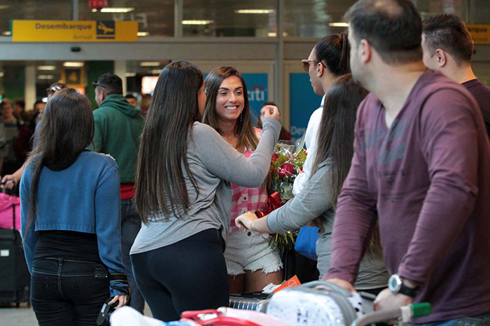 Nicole Bahls recebe flores ao desembarcar em SP