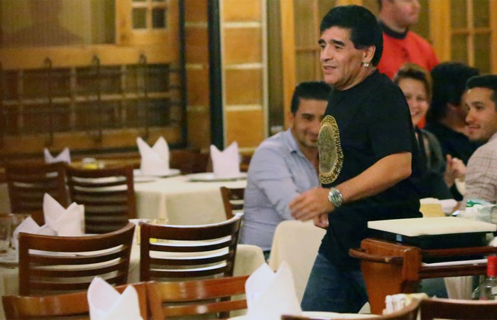 Em clima de festa, Maradona equilibra taça de vinho na testa