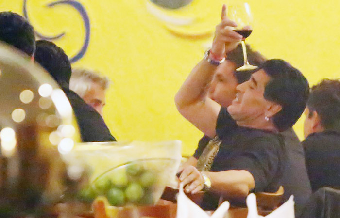 Em clima de festa, Maradona equilibra taça de vinho na testa