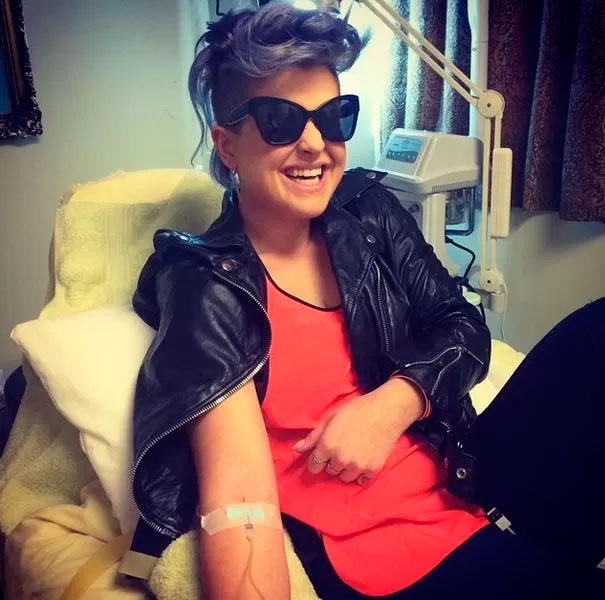 JU Kelly Osbourne mostra bom humor ao tomar vitaminas na veia