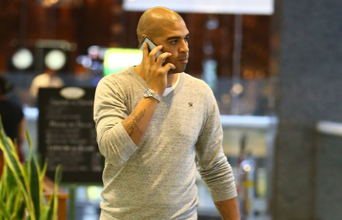  No celular, jogador Adriano passeia em shopping do Rio 