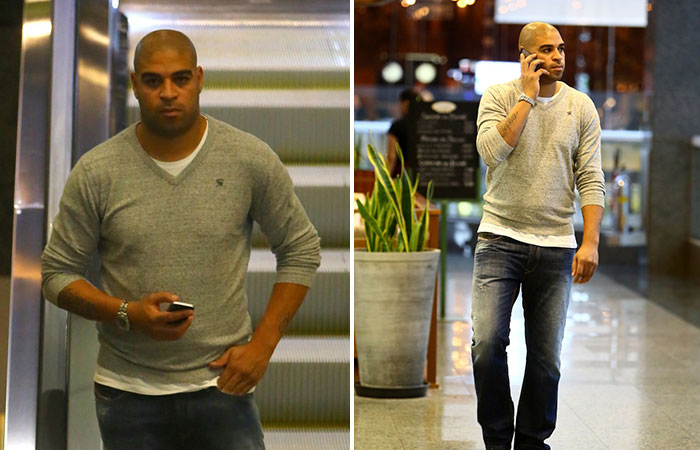  No celular, jogador Adriano passeia em shopping do Rio 