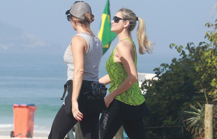 Sorridente, Ellen Roche caminha com amiga na Barra da Tijuca