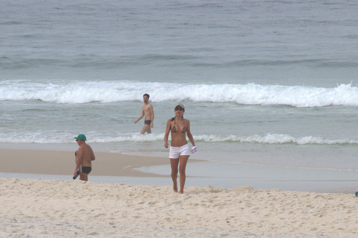 Anna Lima acena para paparazzo em dia de exercícios na praia da Barra