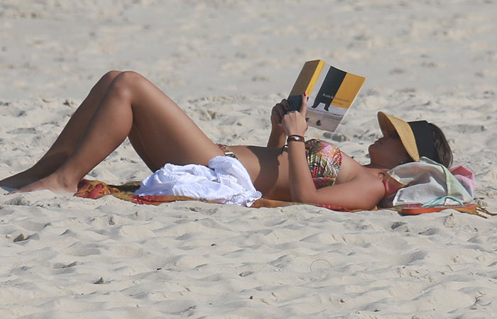  Juliana Knust lê em dia de praia no Rio