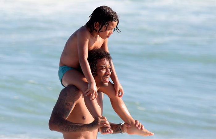  De férias, jogador Marcelo, da seleção, curte dia de praia com amigos e a família