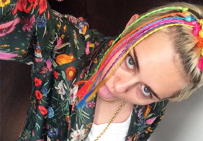 Miley Cyrus esconde espinha no rosto com acessórios coloridos