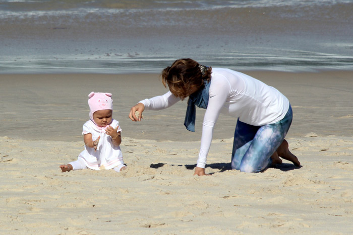 Mãe coruja, Guilhermina Guinle se diverte com Minna em praia carioca