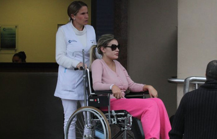 Andressa Urach deixa hospital em cadeira de rodas