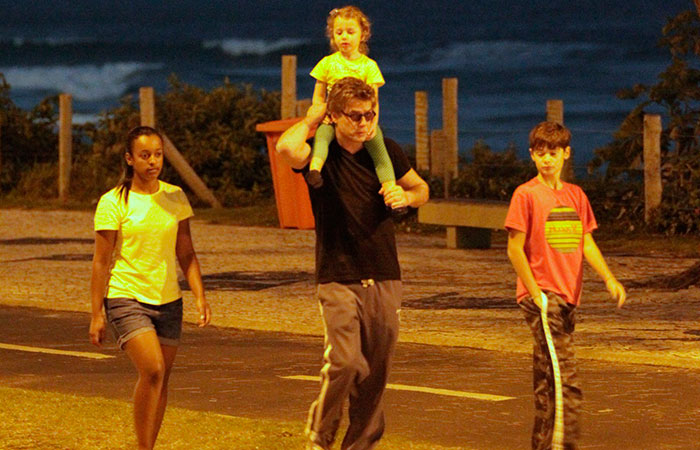 Fábio Asuunção passeia com os filhos, Ella e João, pela orla da Barra da Tijuca, no Rio