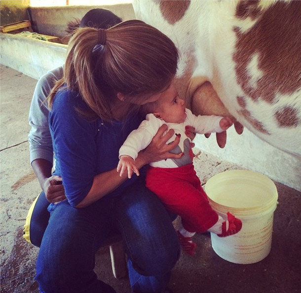 Nívea Stelmann e a filha ordenham vaca em fazenda