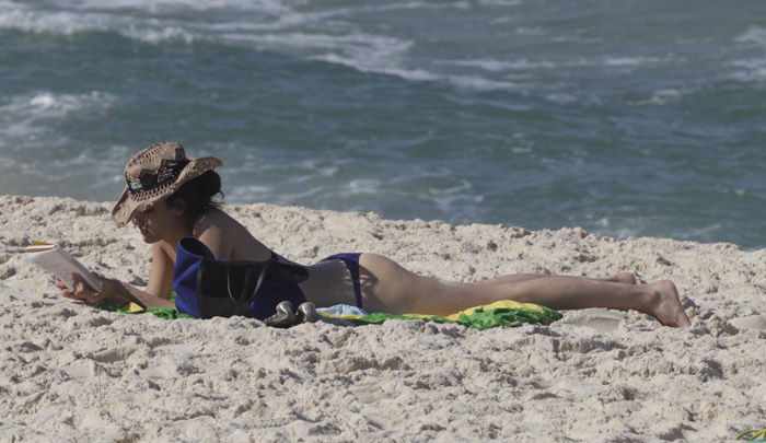 Fernanda Tavares lê na praia da Barra da Tijuca em manhã de sol no Rio