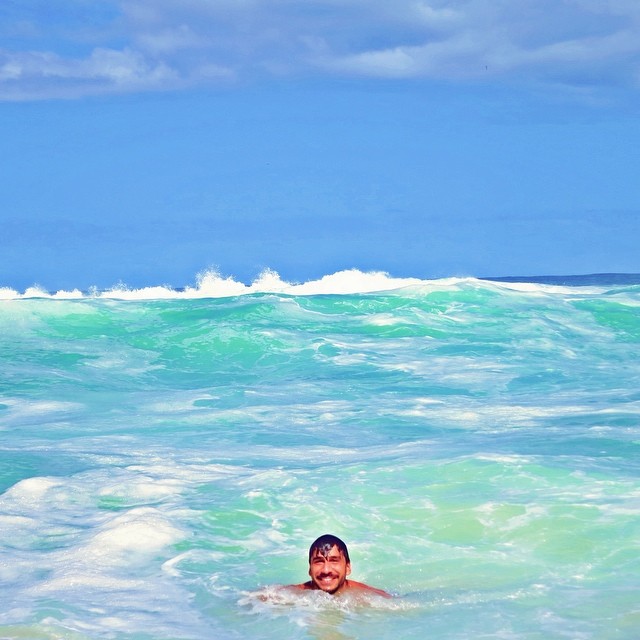 Todo sorridente, Júlio Rocha toma banho de mar