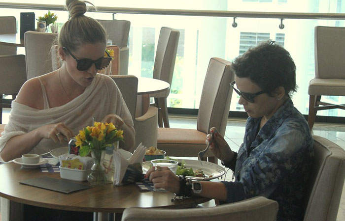 De óculos escuros, Bruna Di Tullio almoça com amiga em shopping carioca