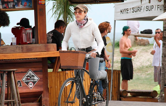 Em dia frio, Christiane Torloni bebe água de coco na orla carioca