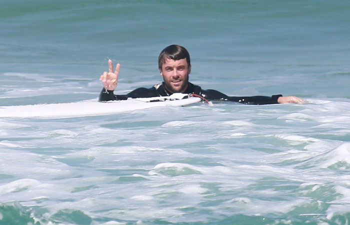 Em dia de praia, Kayky Brito acena para fotógrafo