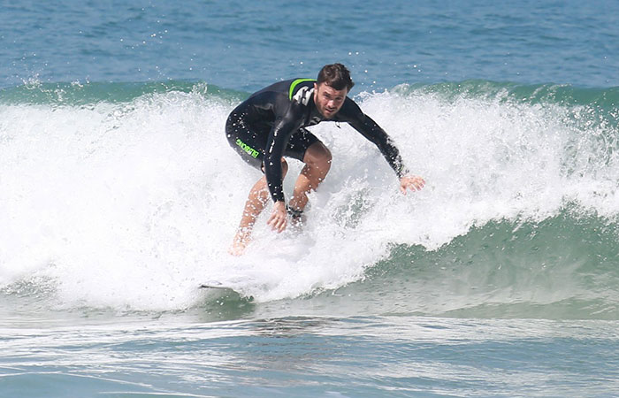 Em dia de praia, Kayky Brito acena para fotógrafo