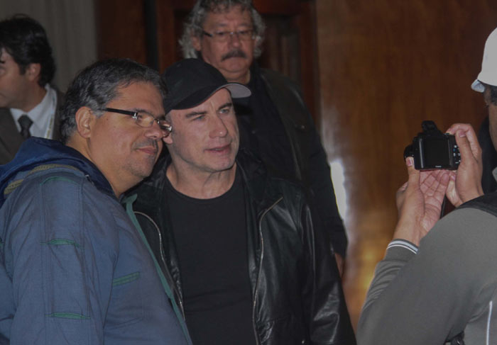 John Travolta atende fãs na saída de hotel em São Paulo