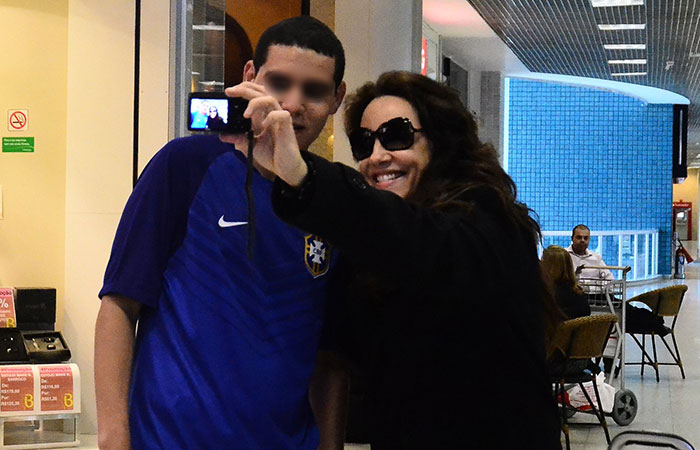 Toda de preto, Ana Carolina posa com fã em aeroporto do Rio de Janeiro