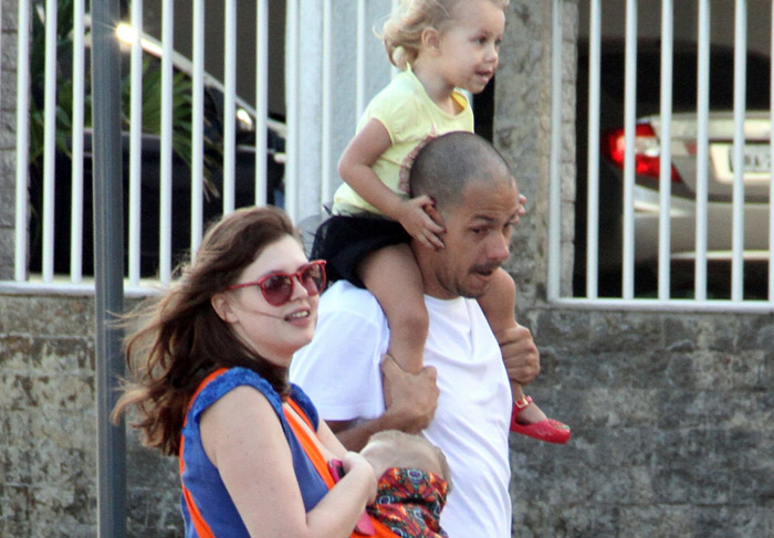 Carolinie Figueiredo passeia com a família e amamenta o pequeno Theo na orla da praia