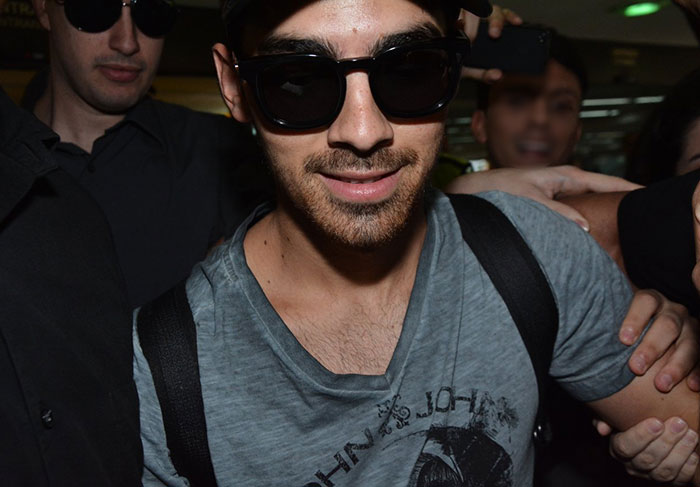 Joe Jonas agita multidão ao desembarcar em São Paulo