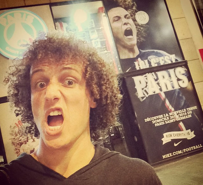 Em Paris, David Luiz posa diante de sua foto na famosa Champs-Élysées