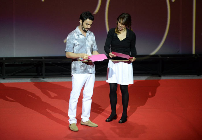 Maria Ribeiro e Caio Blat tiram peças de roupa e se beijam durante premiação