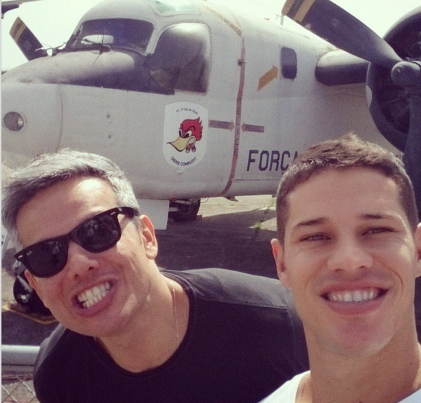 José Loreto e Otaviano Costa posam para selfie com avião da aeronáutica