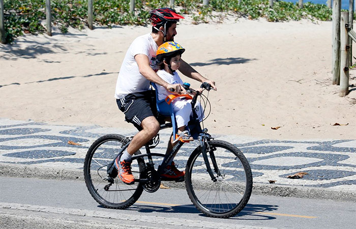 Eriberto Leão passeia de bike com o filho pela orla de Ipanema