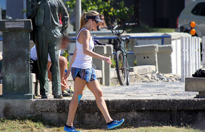 e viseira e óculos escuros, Luana Piovani se exercita nas areias de praia carioca