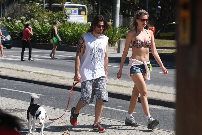 De biquíni, Ellen Jabour caminha com o namorado na Barra da Tijuca