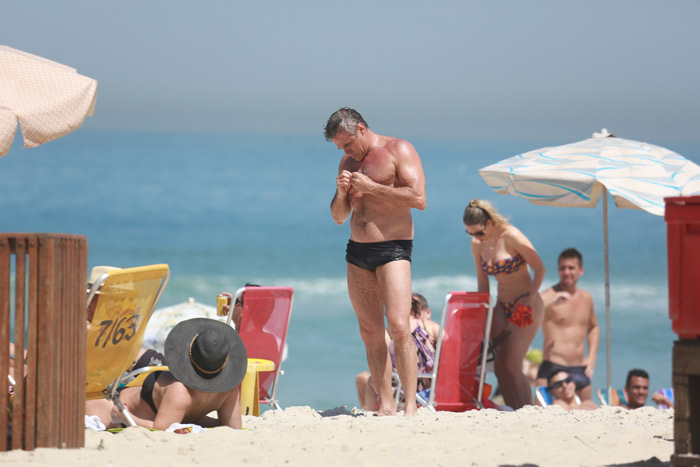 Oscar Magrini cai no riso com fã na praia da Barra