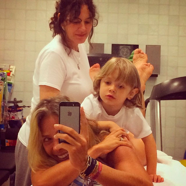 Adriane Galisteu faz massagem com o filho nas costas